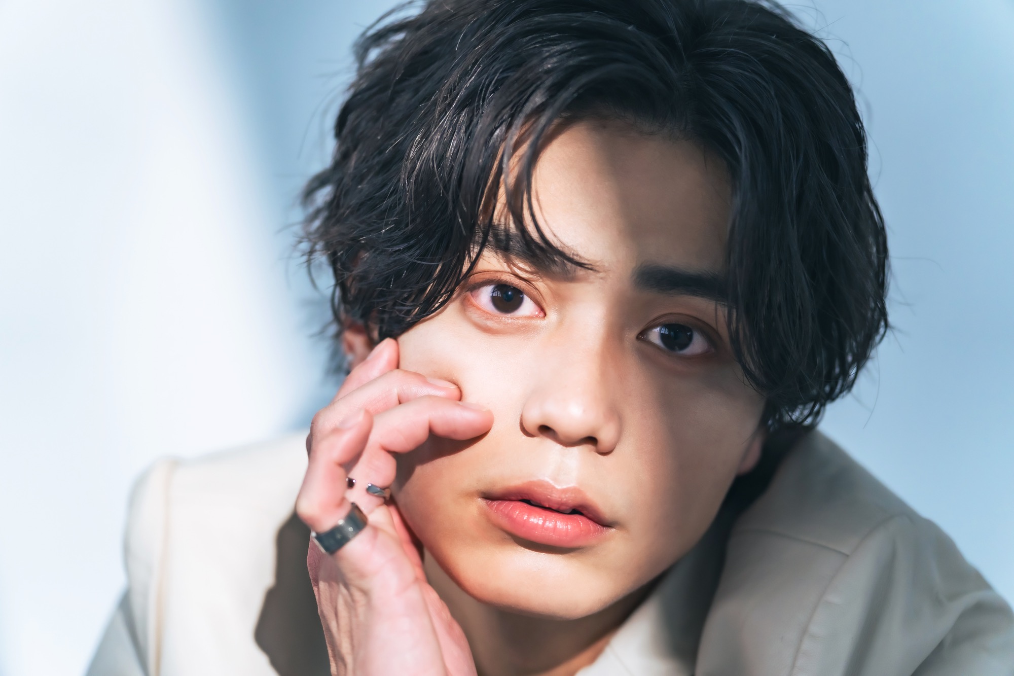 頬に手を添える男性